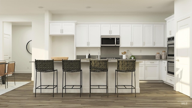 kitchen with dark hardwood / wood-style flooring, white cabinetry, a center island, and stainless steel appliances