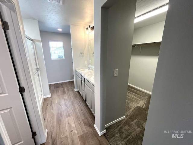 full bathroom with vanity, visible vents, wood finished floors, and baseboards