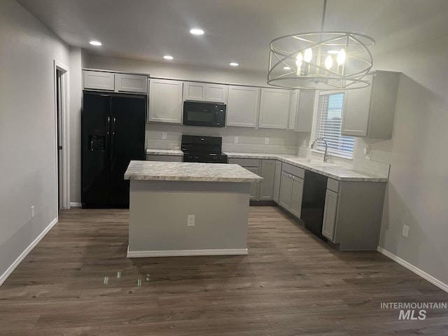 kitchen featuring a chandelier, recessed lighting, dark wood-style flooring, a sink, and black appliances