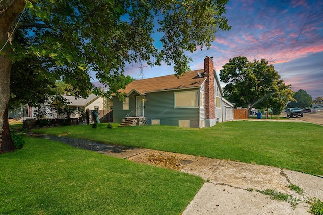 property exterior at dusk featuring a lawn