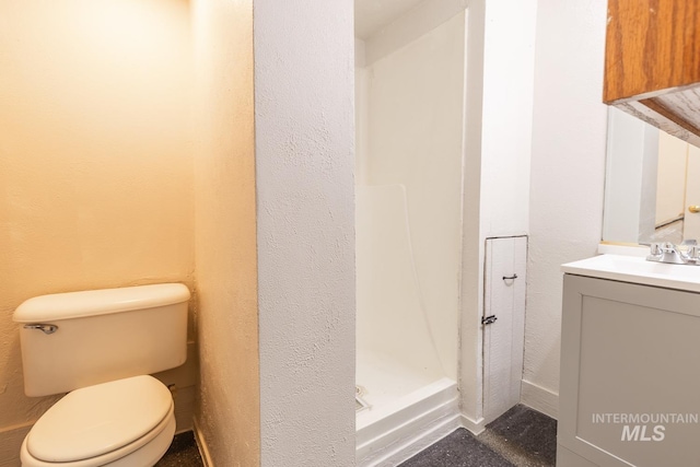 bathroom featuring vanity, walk in shower, and toilet