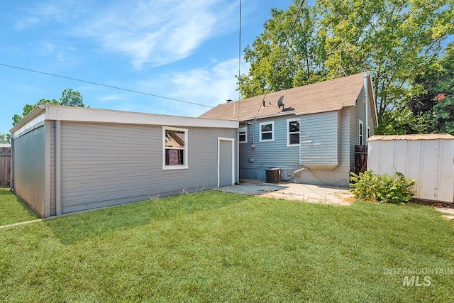 back of property featuring central AC and a lawn