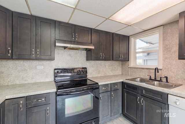 kitchen featuring sink, a paneled ceiling, white dishwasher, and black / electric stove