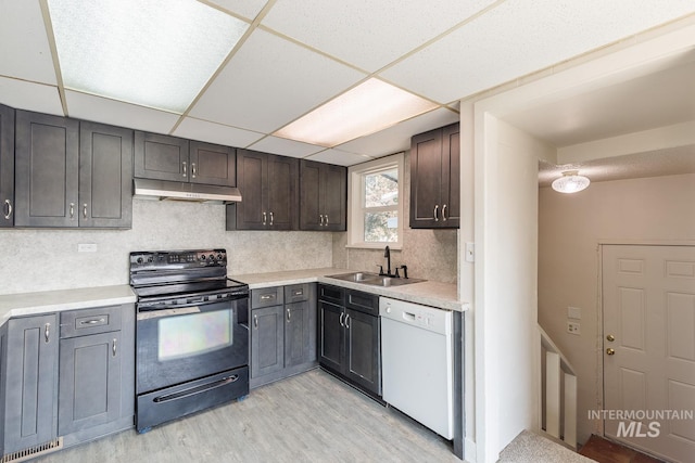 kitchen with sink, white dishwasher, dark brown cabinetry, a drop ceiling, and black / electric stove