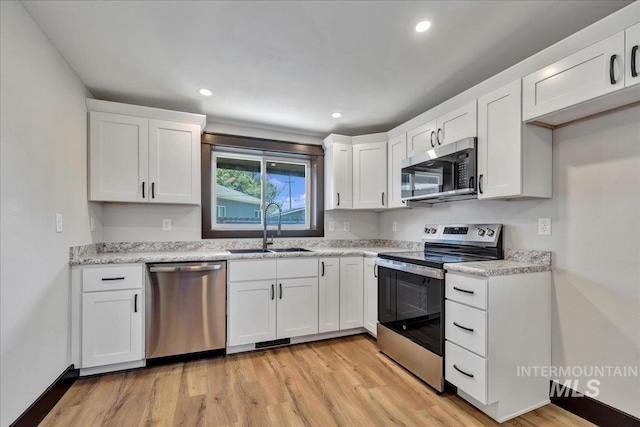 327 Adams St, Twin Falls, ID 83301 - kitchen featuring stainless steel appliances, light wood-style flooring, white cabinets, recessed lighting, and light stone countertops