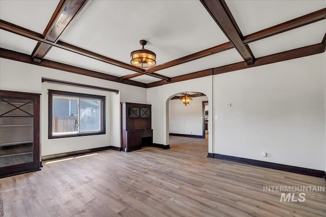 327 Adams St, Twin Falls, ID 83301 - unfurnished living room with coffered ceiling, arched walkways, wood finished floors, and beam ceiling