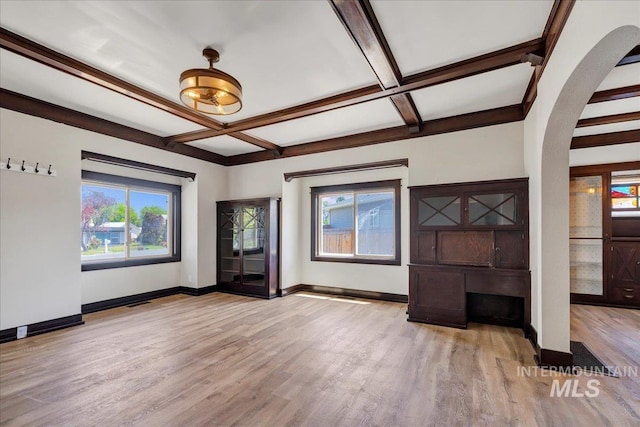 327 Adams St, Twin Falls, ID 83301 - unfurnished living room featuring arched walkways, wood finished floors, coffered ceiling, and beam ceiling