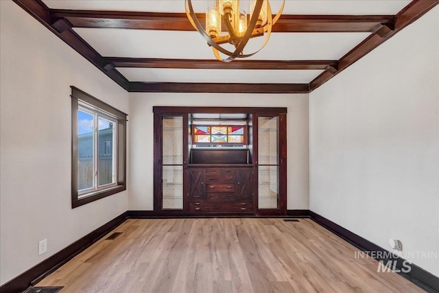 327 Adams St, Twin Falls, ID 83301 - spare room featuring a chandelier, beamed ceiling, light wood-style flooring, and cooling unit