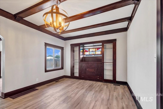 327 Adams St, Twin Falls, ID 83301 - unfurnished room featuring a chandelier, beam ceiling, light wood finished floors, and arched walkways