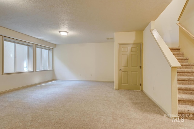 9407 W Pebblestream Dr, Boise, ID 83709 - below grade area with light carpet, stairway, and a textured ceiling