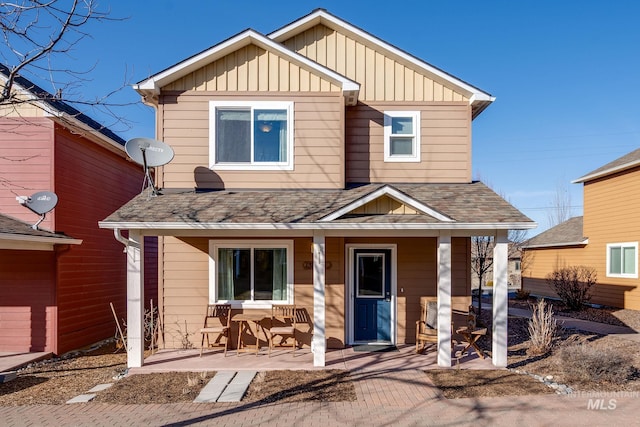 view of front of home with roof with shingles, a porch, and board and batten siding