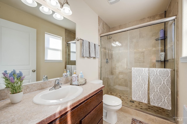 bathroom featuring toilet, a shower stall, tile patterned flooring, and vanity