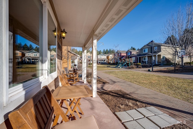 view of patio / terrace with a residential view, covered porch, and a playground