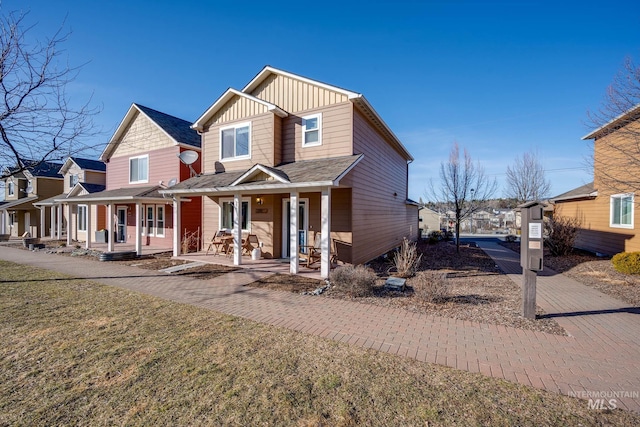 view of front facade with a front lawn, a porch, and board and batten siding