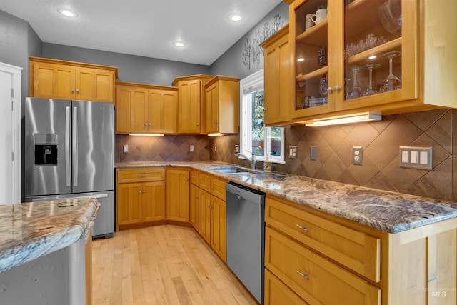 1390 E Prohaska Ct, Eagle, ID 83616 - kitchen featuring stainless steel appliances, light wood-style flooring, light stone counters, glass insert cabinets, and tasteful backsplash