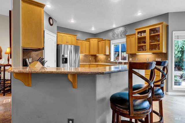 1390 E Prohaska Ct, Eagle, ID 83616 - kitchen featuring stainless steel refrigerator with ice dispenser, a kitchen breakfast bar, plenty of natural light, a peninsula, and recessed lighting
