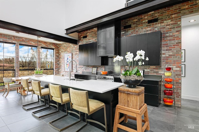 278 S Carbon Rivet Ave, Eagle, ID 83616 - kitchen featuring a sink, dark cabinets, light countertops, brick wall, and baseboards