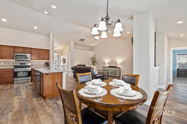 3499 S Green Basin Way, Nampa, ID 83686 - dining area featuring a chandelier, wood finished floors, recessed lighting, and lofted ceiling