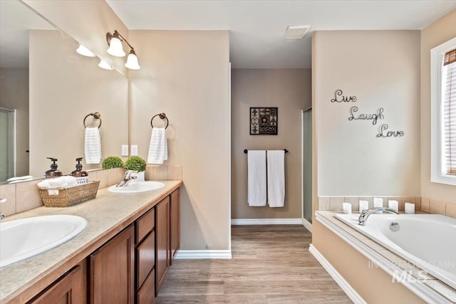 3499 S Green Basin Way, Nampa, ID 83686 - bathroom with wood finished floors, double vanity, a bath, and a stall shower