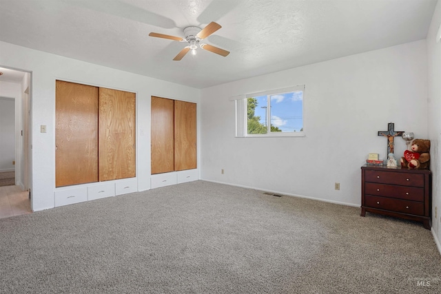 1520 R St, Heyburn, ID 83336 - unfurnished bedroom with multiple closets, baseboards, light colored carpet, and a ceiling fan