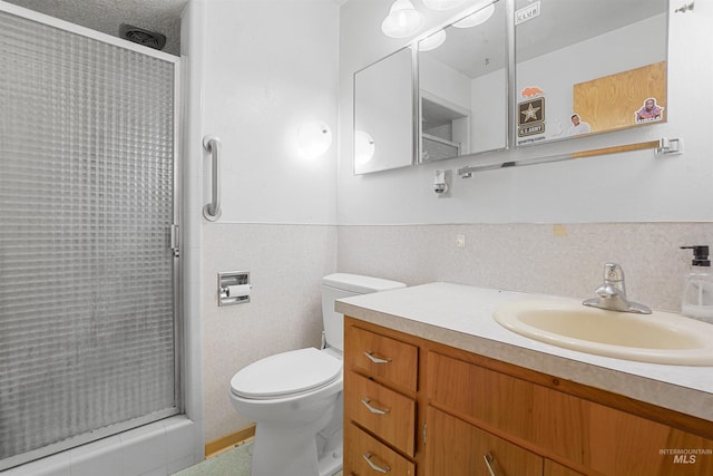 1520 R St, Heyburn, ID 83336 - bathroom featuring a shower stall, vanity, toilet, tile walls, and a wainscoted wall