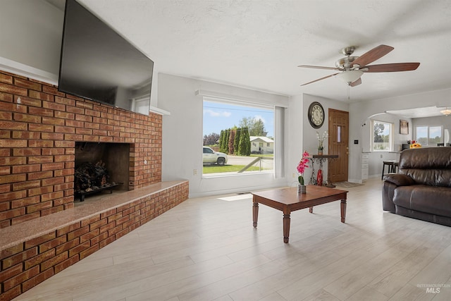 1520 R St, Heyburn, ID 83336 - living room with ceiling fan, a brick fireplace, wood finished floors, and arched walkways