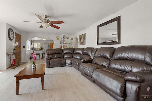 1520 R St, Heyburn, ID 83336 - living area featuring arched walkways, a ceiling fan, light wood finished floors, and built in features