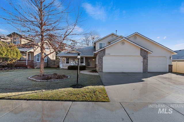 view of front of house featuring covered porch, a garage, and a front yard