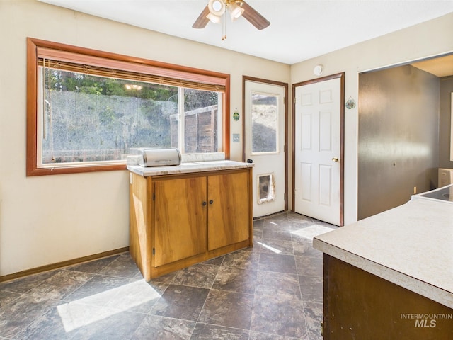143 Timberline Dr, Pierce, ID 83546 - kitchen with brown cabinets, baseboards, ceiling fan, and light countertops