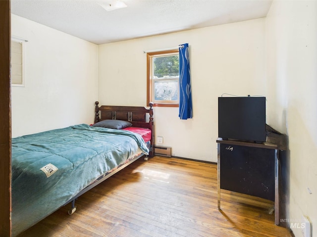143 Timberline Dr, Pierce, ID 83546 - bedroom with wood-type flooring and baseboard heating