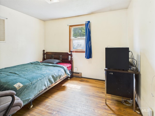 143 Timberline Dr, Pierce, ID 83546 - bedroom featuring a baseboard heating unit and hardwood / wood-style flooring