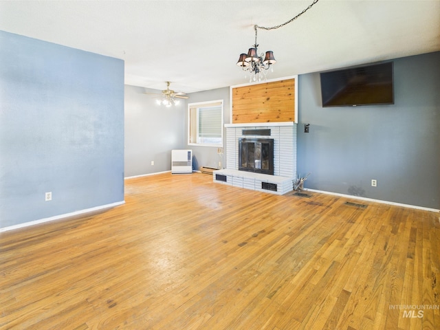 143 Timberline Dr, Pierce, ID 83546 - unfurnished living room featuring an inviting chandelier, visible vents, a fireplace, baseboards, and light wood finished floors