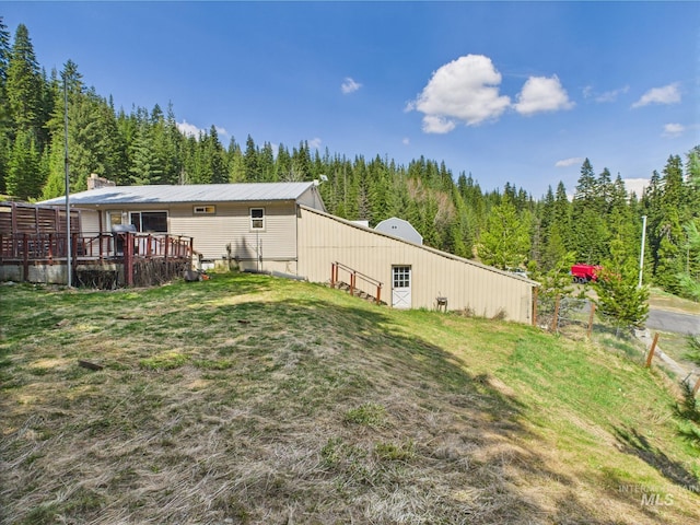 143 Timberline Dr, Pierce, ID 83546 - rear view of house featuring a lawn, a view of trees, a pole building, and an outdoor structure