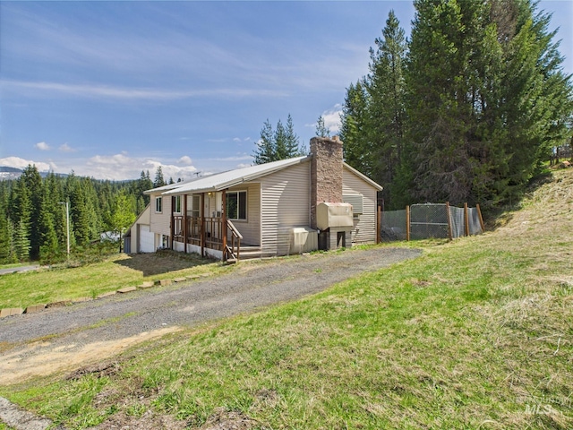 143 Timberline Dr, Pierce, ID 83546 - manufactured / mobile home with a garage, a front lawn, fence, a chimney, and a porch