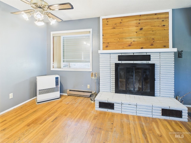 143 Timberline Dr, Pierce, ID 83546 - unfurnished living room featuring a ceiling fan, wood finished floors, baseboards, a baseboard radiator, and heating unit