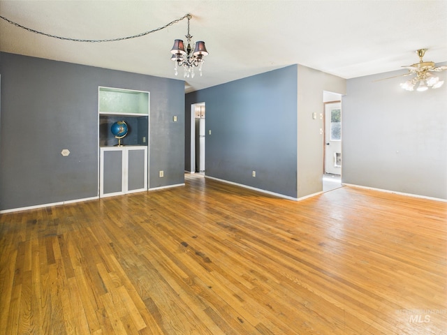 143 Timberline Dr, Pierce, ID 83546 - unfurnished room with baseboards, built in shelves, hardwood / wood-style flooring, and ceiling fan with notable chandelier