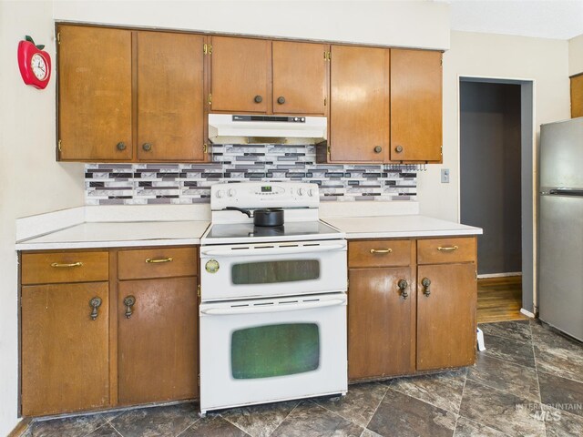 143 Timberline Dr, Pierce, ID 83546 - kitchen with freestanding refrigerator, decorative backsplash, light countertops, under cabinet range hood, and double oven range