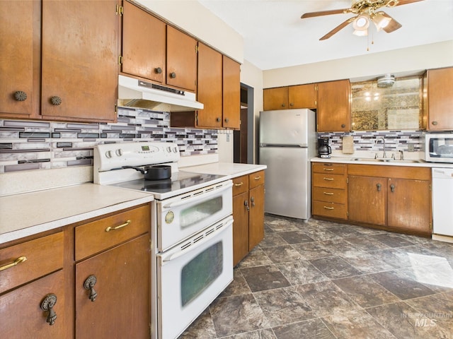 143 Timberline Dr, Pierce, ID 83546 - kitchen with brown cabinets, appliances with stainless steel finishes, a sink, tasteful backsplash, and under cabinet range hood