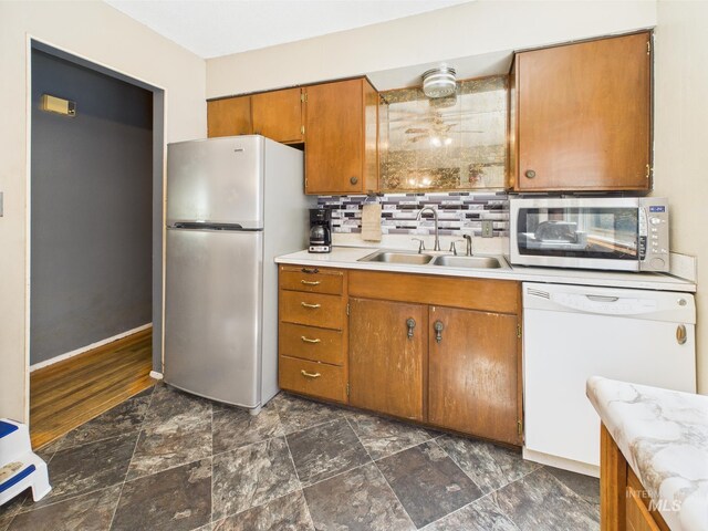 143 Timberline Dr, Pierce, ID 83546 - kitchen featuring backsplash, stainless steel appliances, brown cabinetry, and a sink