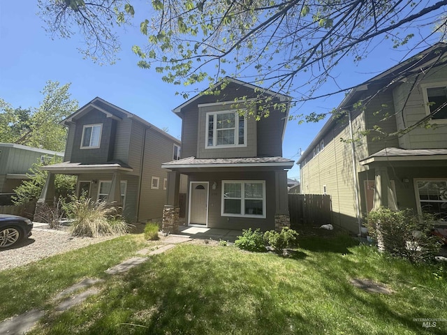 view of front of house with covered porch, fence, and a front yard