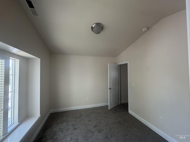 interior space with vaulted ceiling, baseboards, and visible vents
