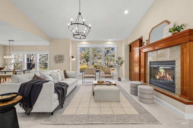 carpeted living room with a fireplace, a notable chandelier, and vaulted ceiling