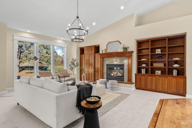 carpeted living room with a fireplace, an inviting chandelier, and vaulted ceiling