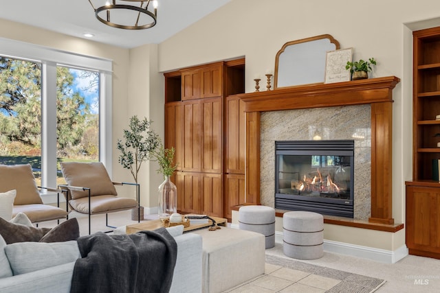 living room featuring a premium fireplace, light colored carpet, plenty of natural light, and built in features