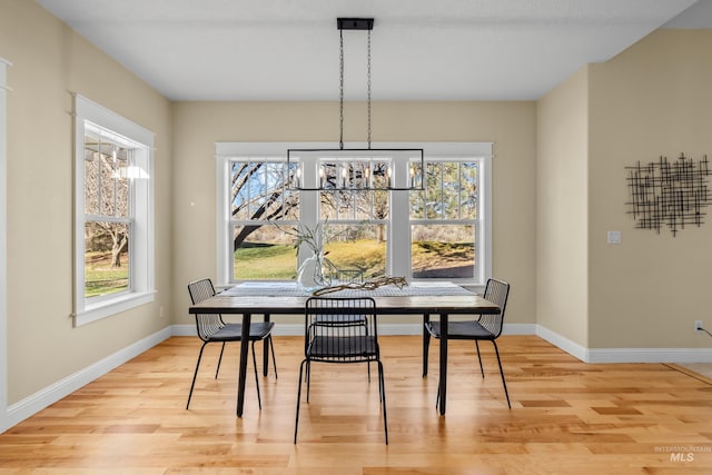 dining room with light wood-type flooring and a chandelier