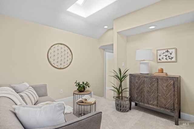 sitting room with vaulted ceiling with skylight and carpet flooring