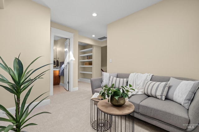 living room featuring built in shelves and light carpet