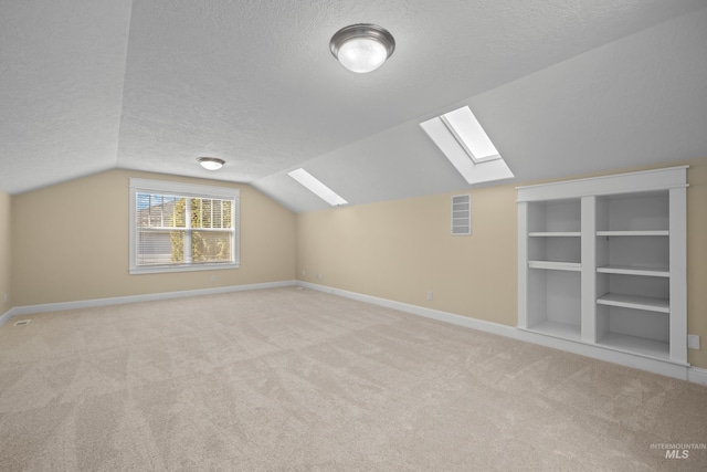 additional living space with light colored carpet, a textured ceiling, and lofted ceiling