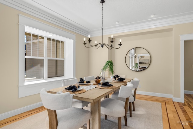 dining room with ornamental molding, light hardwood / wood-style floors, and a chandelier