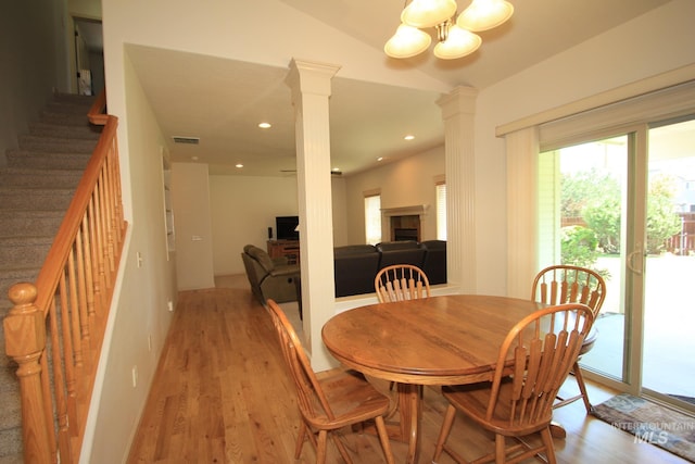 1491 N Millstream Ct, Nampa, ID 83686 - dining room featuring light wood-type flooring, decorative columns, stairway, a chandelier, and a fireplace